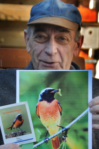 Wiily Becker mit Plakat des Gartenrotschwanzes
